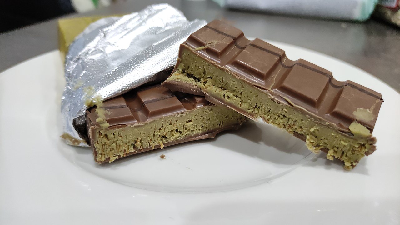 Barra de Dubai Chocolate cortada ao meio, mostrando recheio de pistache e fios de kataifi tostado