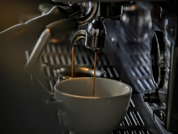 Espresso sendo extraído da máquina profissional